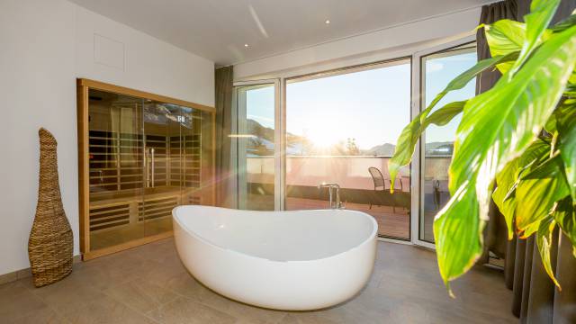 Innenansicht Suite mit Badewanne und Sauna mit Balkon